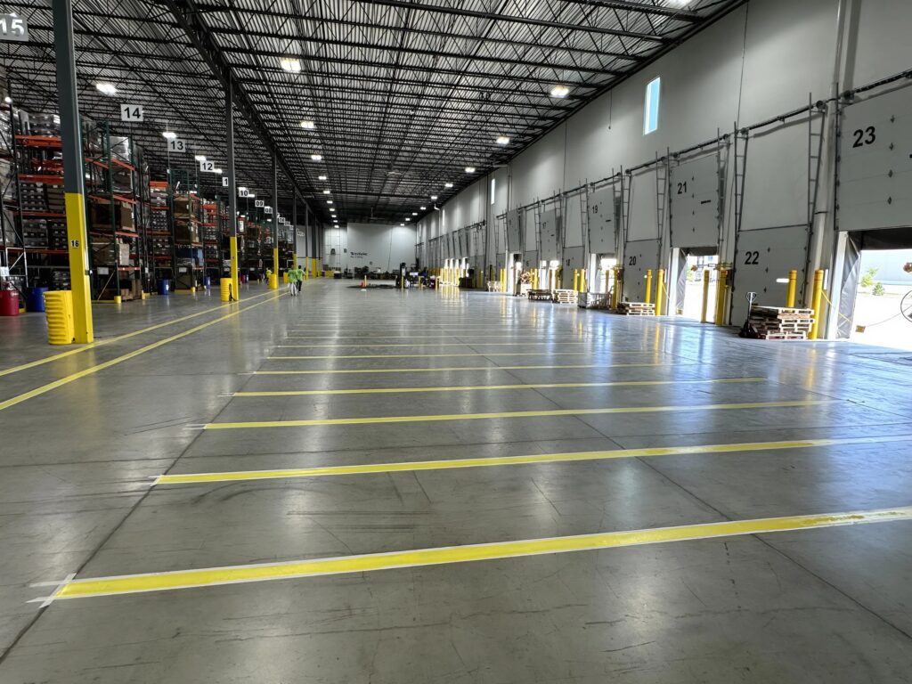 Warehouse floor striping by commercial painter in Crestwood, KY, showing organized loading and staging lanes